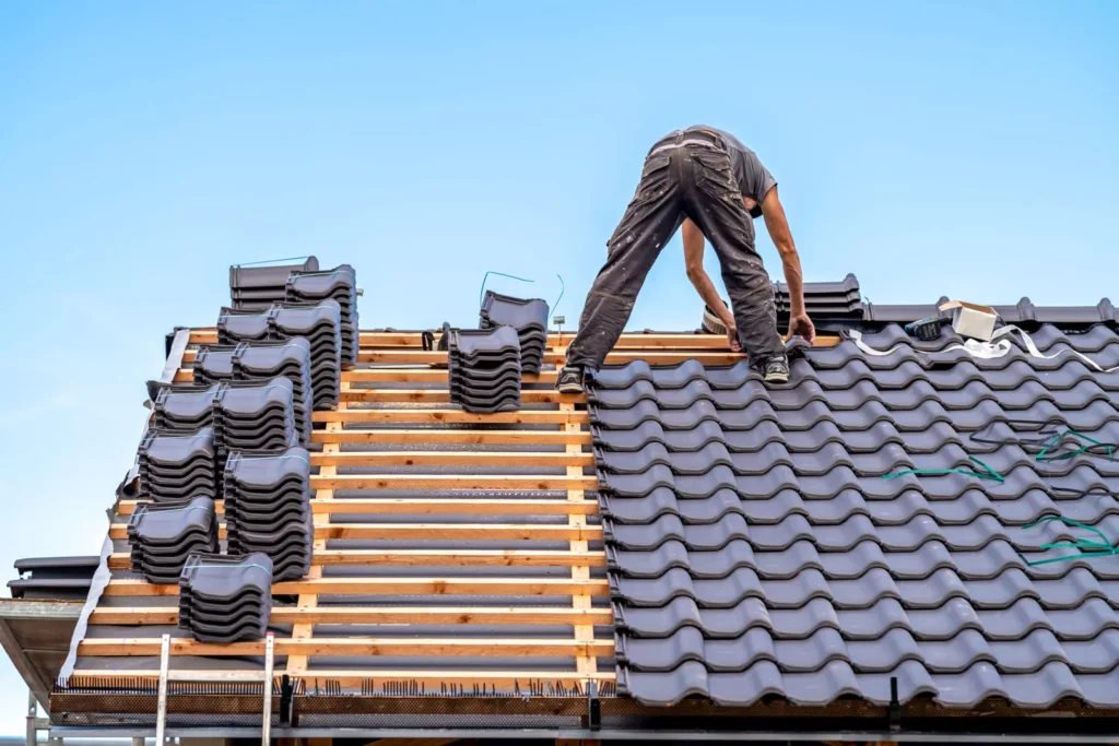 professional roofers installing interlocking dark gray tiles on a new residential construction project in Columbus.