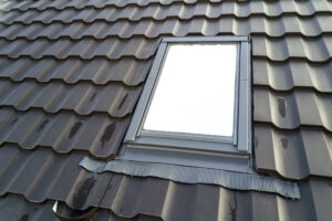 close up of new attic plastic window installed in shingled house roof. professionally done building and construction work, roofing and installation concept.